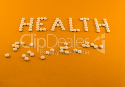 Health word written with pills of supplement