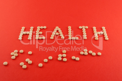 Health word written with pills of supplement