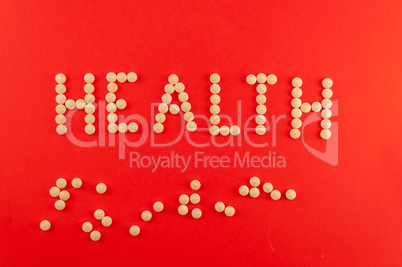 Health word written with pills of supplement