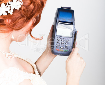 The concept of electronic payment. Closeup a beautiful bride holding credit card over pos terminal