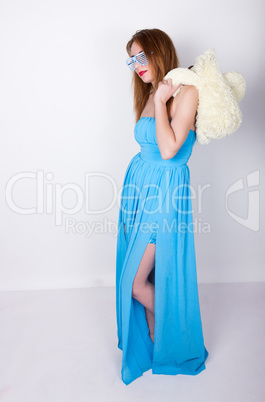 girl in a blue dress and sunglasses in the style of disco, hugging  teddy bear in the same glasses