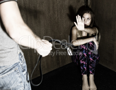 frightened woman sitting in the corner with a faceless man holding belt, conceptual shoot portraying process and effects of domestic violence
