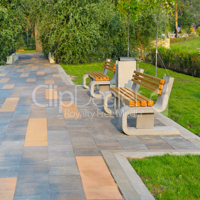 city park with a beautiful promenade, benches and green lawns