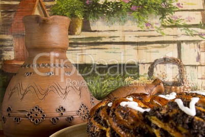 Clay pots for coffee and a roll with poppy seeds