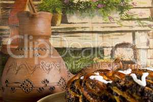 Clay pots for coffee and a roll with poppy seeds