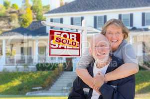 Senior Adult Couple in Front of Real Estate Sign, House
