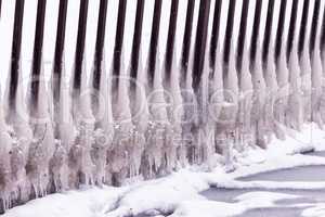 Cold winter day with many icicle on the fence