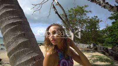 Beautiful young woman posing on tropical beach during summer day