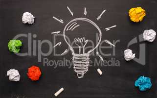 New idea concept with handdrawn lightbulb and crumpled paper