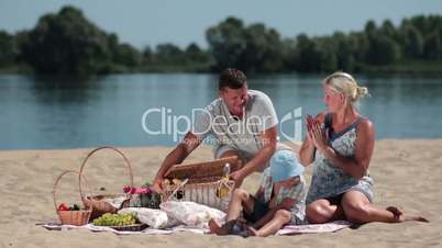 Happy family having picnic on the beach