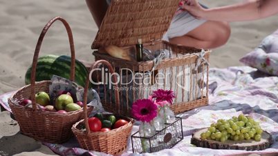 Picnic basket on colorful blanket on the beach