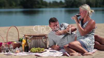 Young couple drinking red wine on picnic