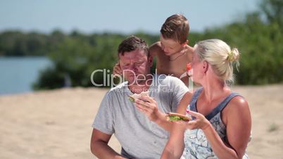 Happy family enjoying lunch on the beach