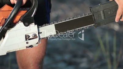 Close up view of man holding chainsaw