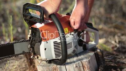 Close up man hands starting chainsaw