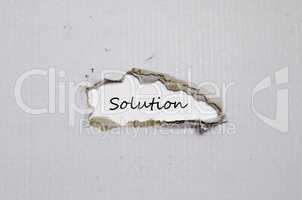 The word solution appearing behind torn paper