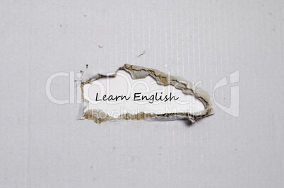 The word learn english appearing behind torn paper