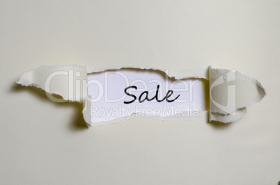 The word sale appearing behind torn paper