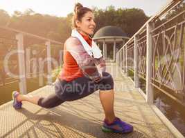 Young beautiful woman doing fitness in a park.