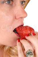 Closeup woman eating strawberry.