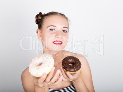 young woman in bright makeup eating a tasty donut with icing. Funny joyful woman with sweets, dessert. dieting concept. junk food. girl licking their fingers