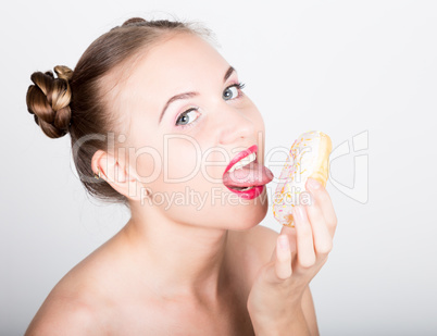 young woman in bright makeup eating a tasty donut with icing. Funny joyful woman with sweets, dessert. dieting concept. junk food. girl licking their fingers