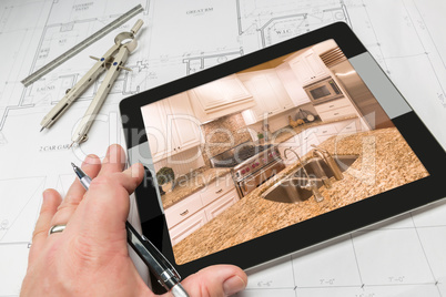 Hand of Architect on Computer Tablet Showing Kitchen Photo Over