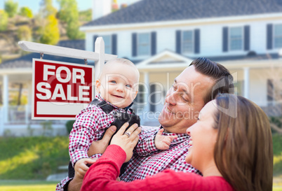 Young Family In Front of For Sale Sign and House