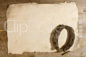 Old horseshoe and a sheet of paper