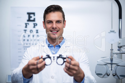 Smiling optometrist holding messbrille