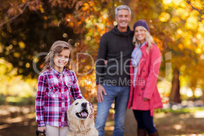 Girl with dog while parents standing at park