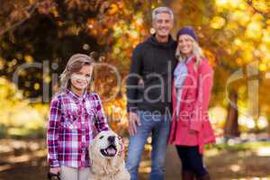 Girl with dog while parents standing at park