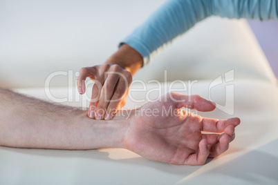 Therapist checking patient pulse