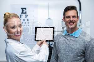 Female optometrist having discussion with patient on digital tab