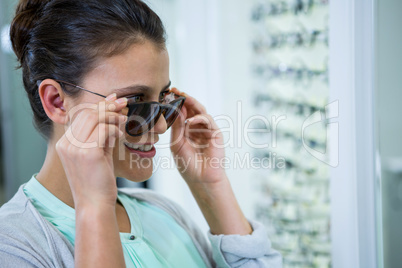 Smiling female customer trying spectacles