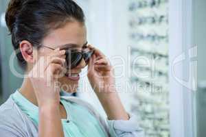 Smiling female customer trying spectacles