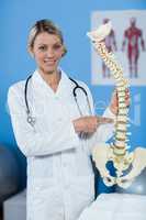 Portrait of physiotherapist holding spine model