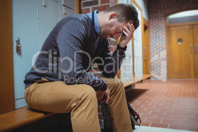 Stressed mature student sitting in locker room