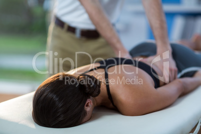 Male physiotherapist giving back massage to female patient