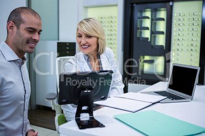 Female optometrist talking to male patient