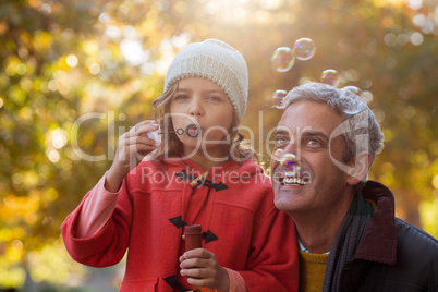 Happy father with daughter blowing bubbles