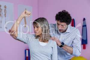 Physiotherapist giving shoulder massage to patient
