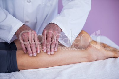 Physiotherapist giving leg massage to a woman