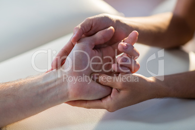 Physiotherapist giving hand massage to patient