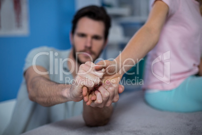 Physiotherapist massaging hand of a female patient