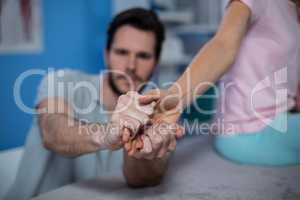 Physiotherapist massaging hand of a female patient