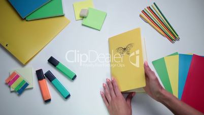 Female hand opening notepad on the table