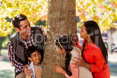 Playful family standing by tree