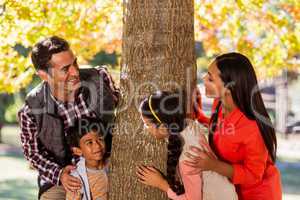 Playful family standing by tree