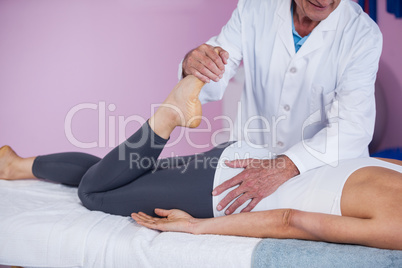 Physiotherapist giving leg massage to a woman